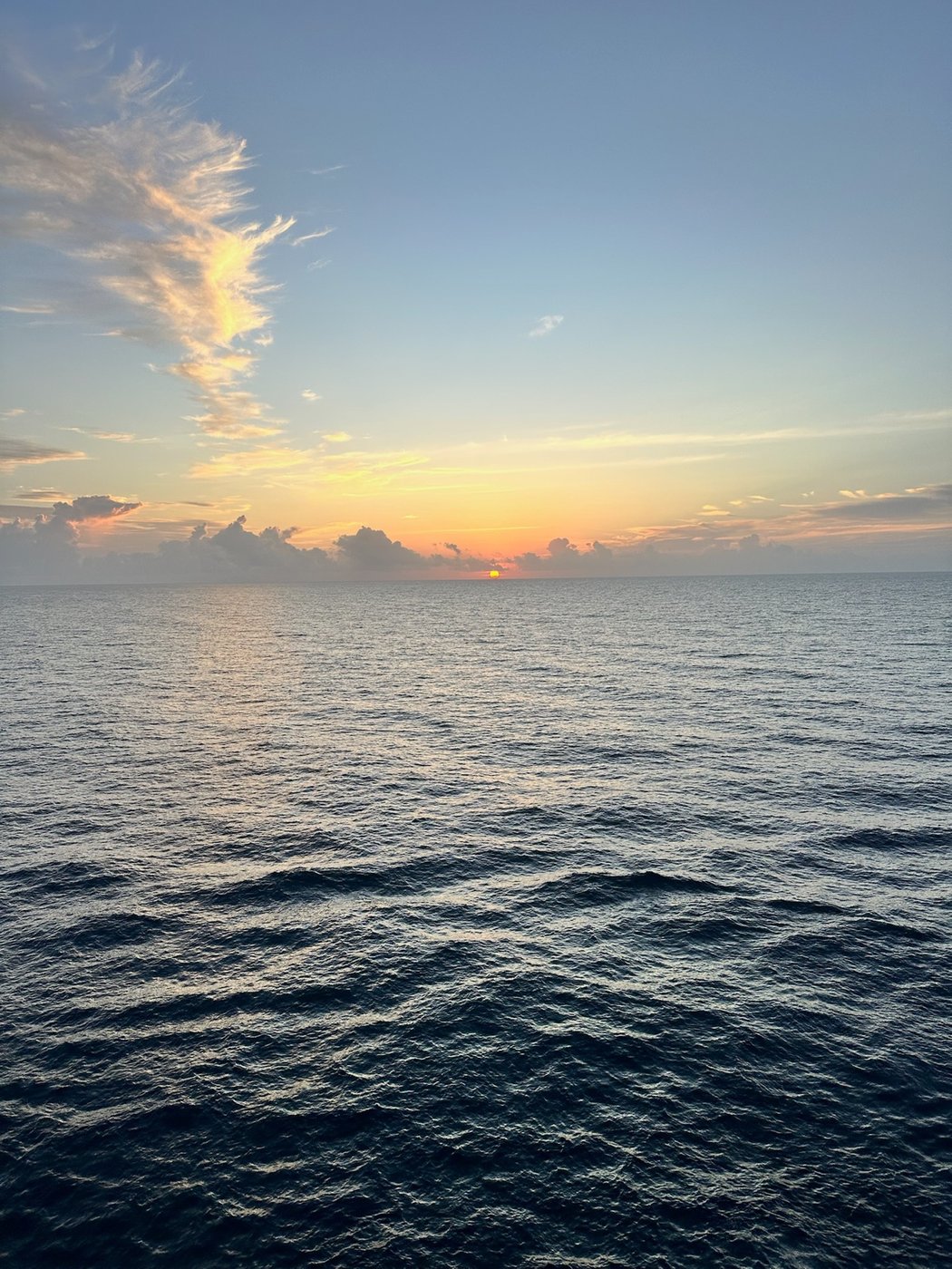 Sunset over the water from a cruise ship rail
